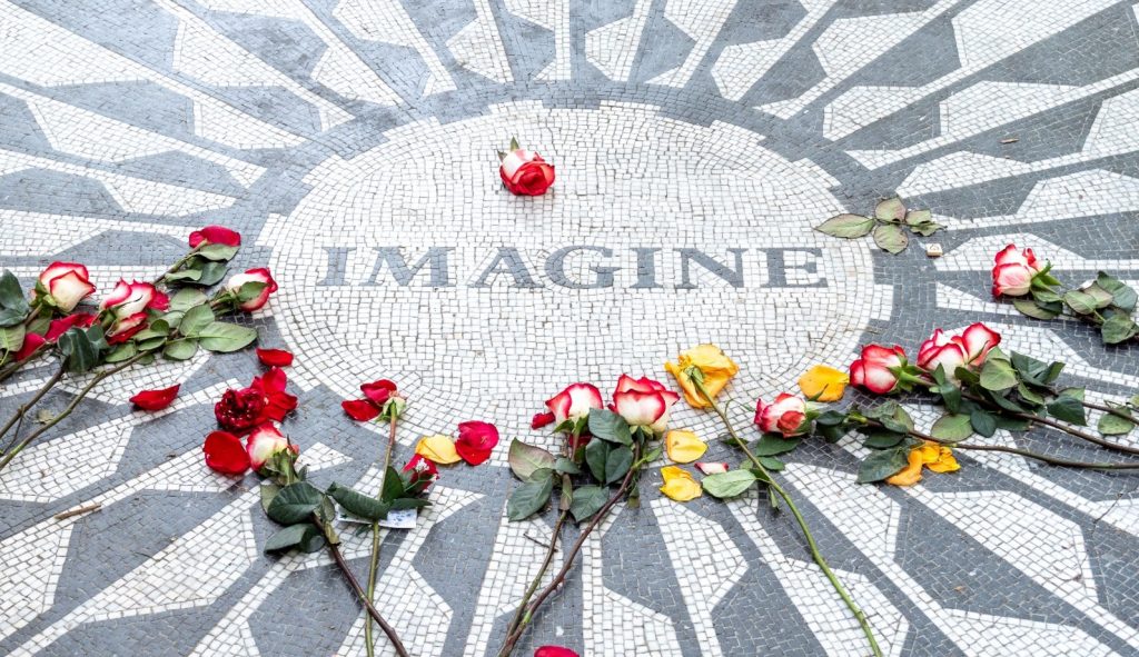 A tiled memorial with the word "imagine" surrounded by flowers.