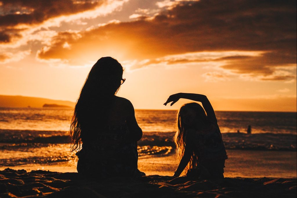 A mother and child at sunset in silhouette