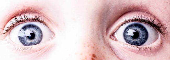 A closeup photo of a person's blue eyes.